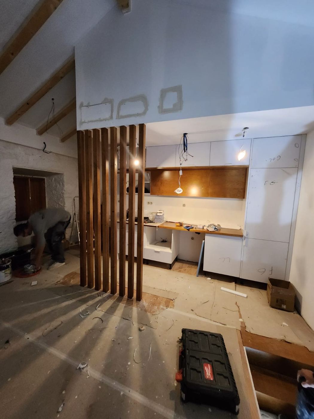 Cozinha com divisória em ripado de madeira, em obra