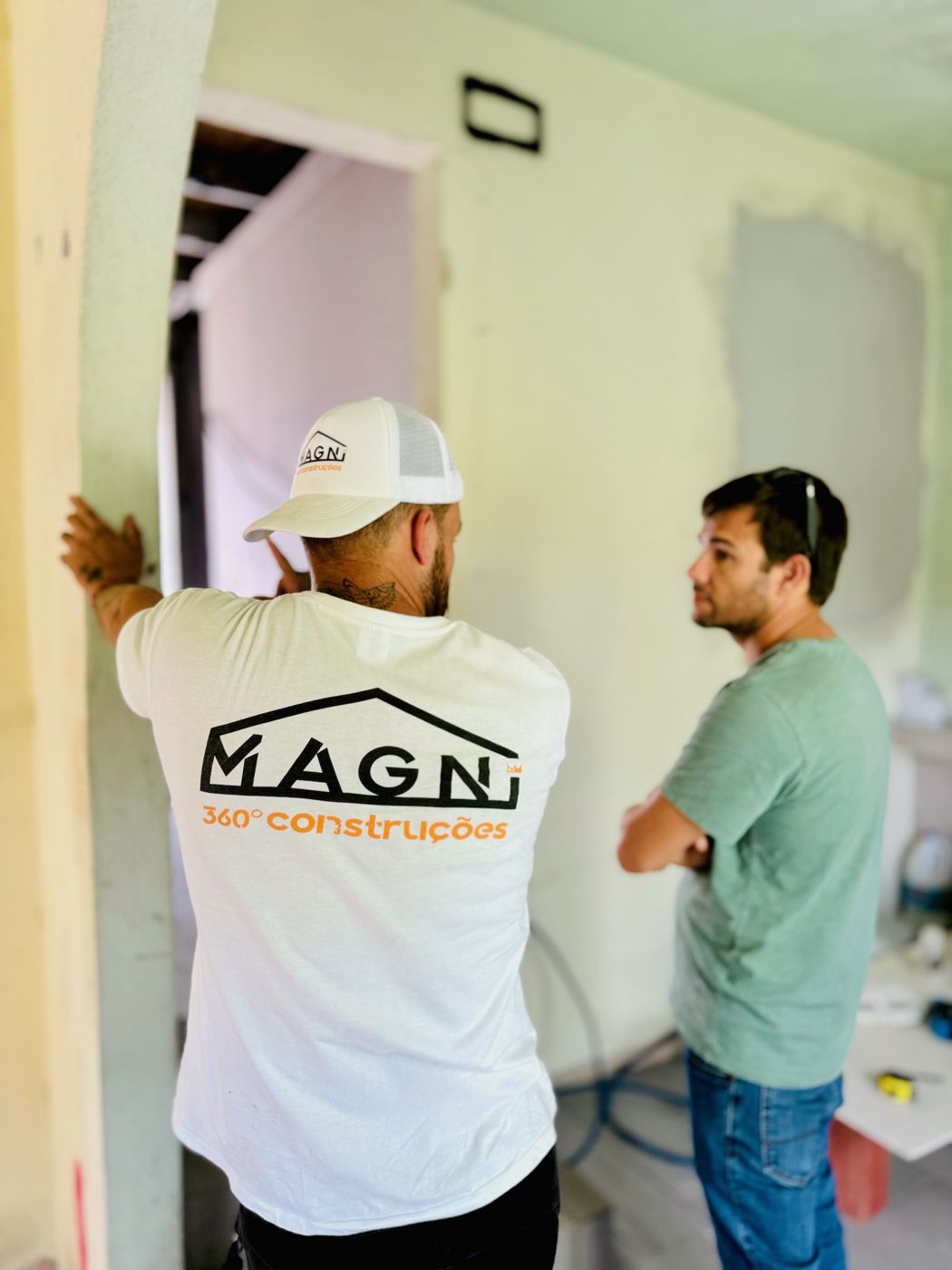 Equipa da Magni em obra, com as t-shirts da empresa, a falar com um cliente